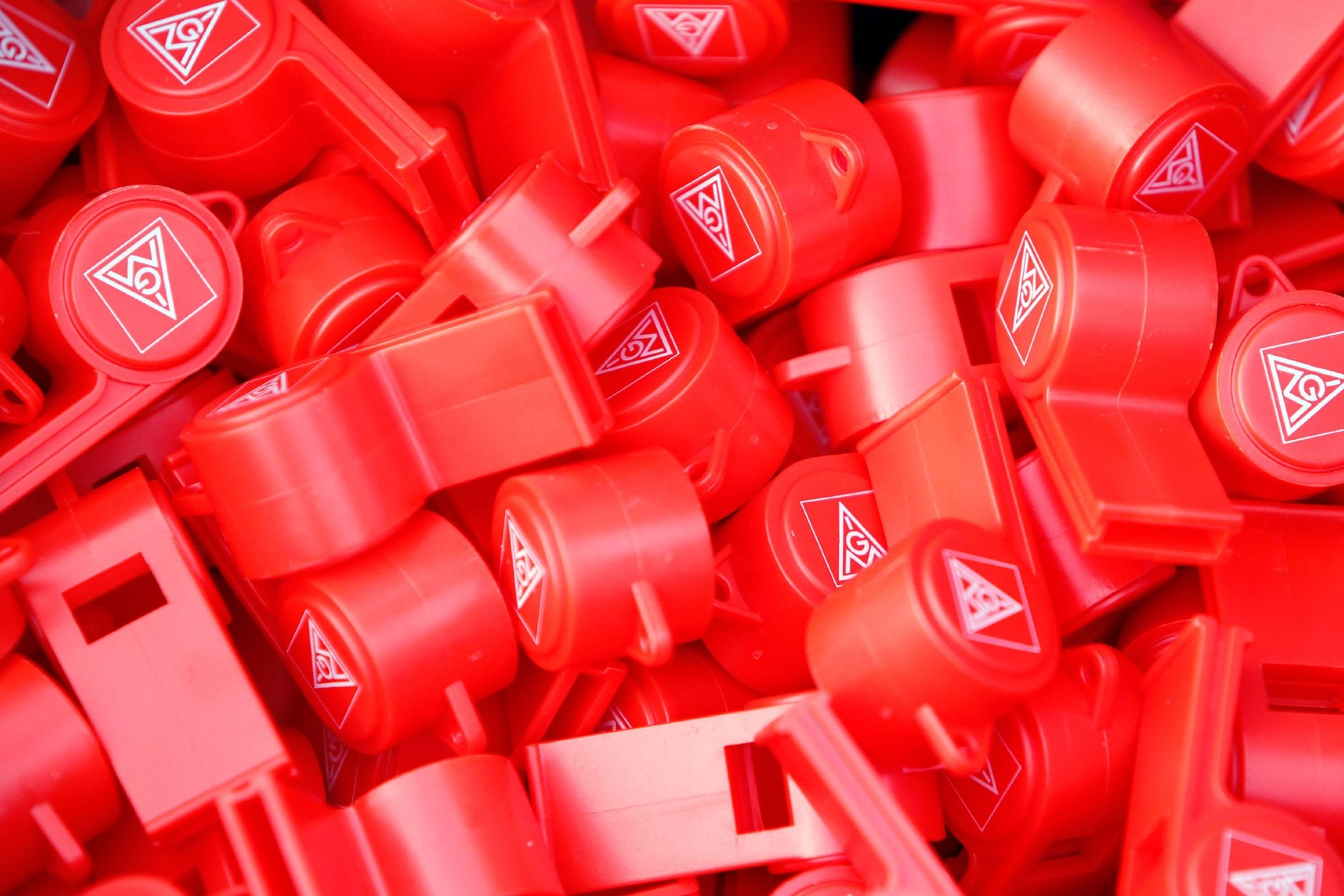 Viele roter Trillerpfeifen mit dem IG Metall Logo.